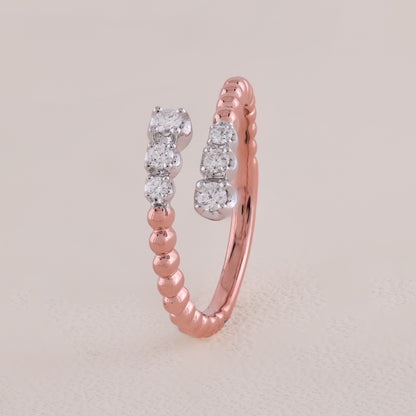 Rose gold ring with diamond accents on a light beige background