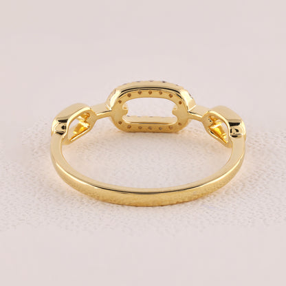 Gold ring with a unique design on a light pink background
