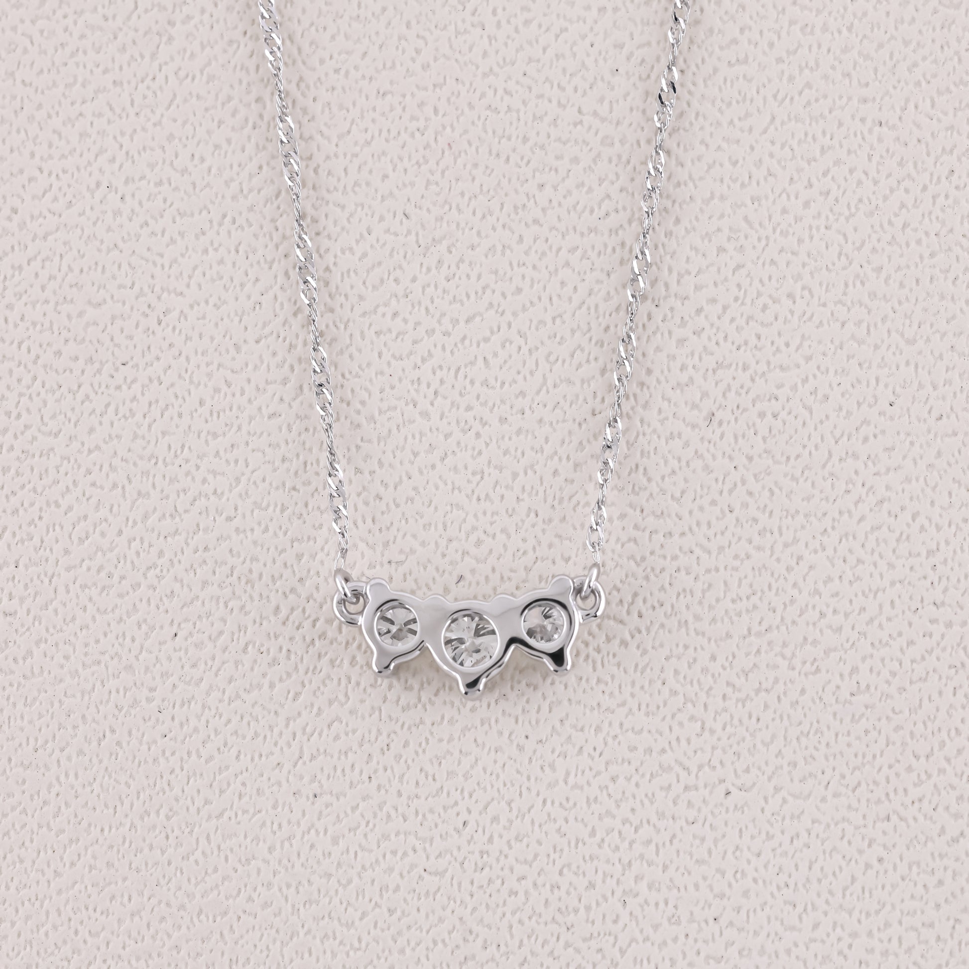 Silver necklace with a unique pendant on a light gray background