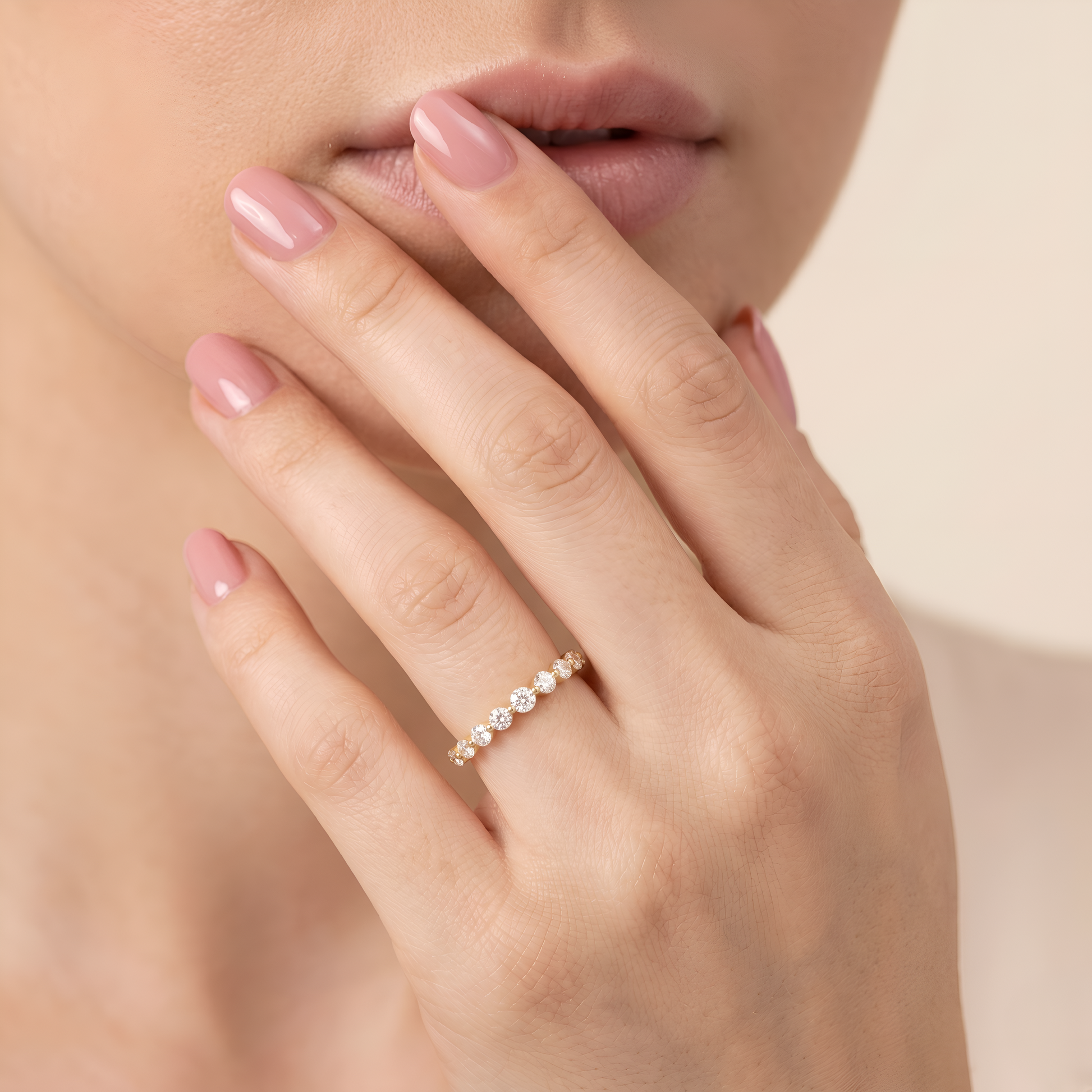 Close-up of a woman's hand wearing a silver ring on a neutral background