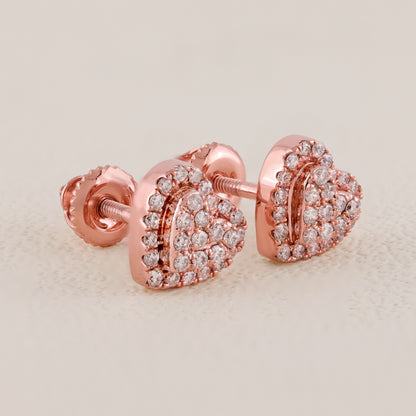Rose gold heart-shaped earrings with clear gemstones on a beige background