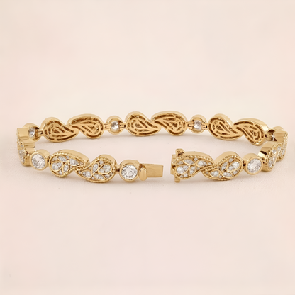Gold bracelet with intricate design on a beige background