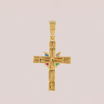 Gold cross pendant with colored stones on a beige background