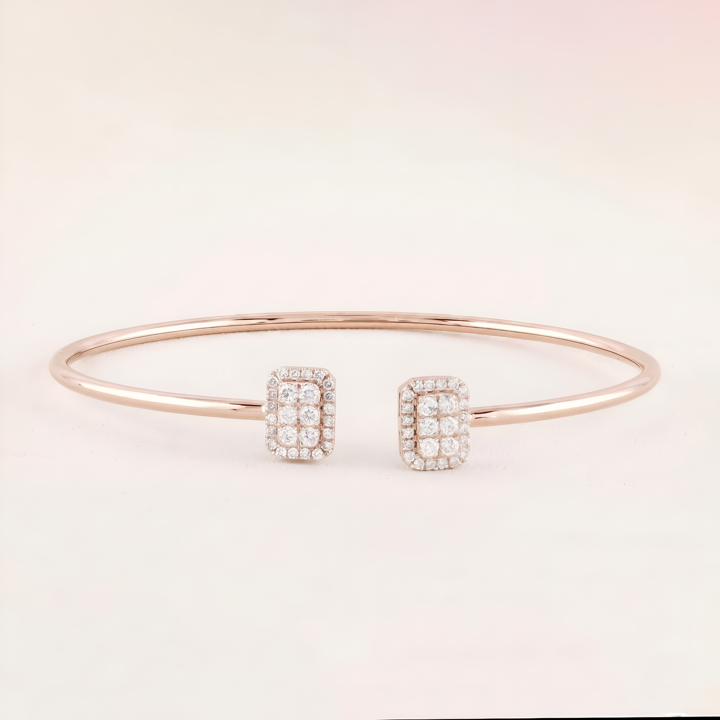 Rose gold bracelet with diamond-studded rectangular charms on a light pink background
