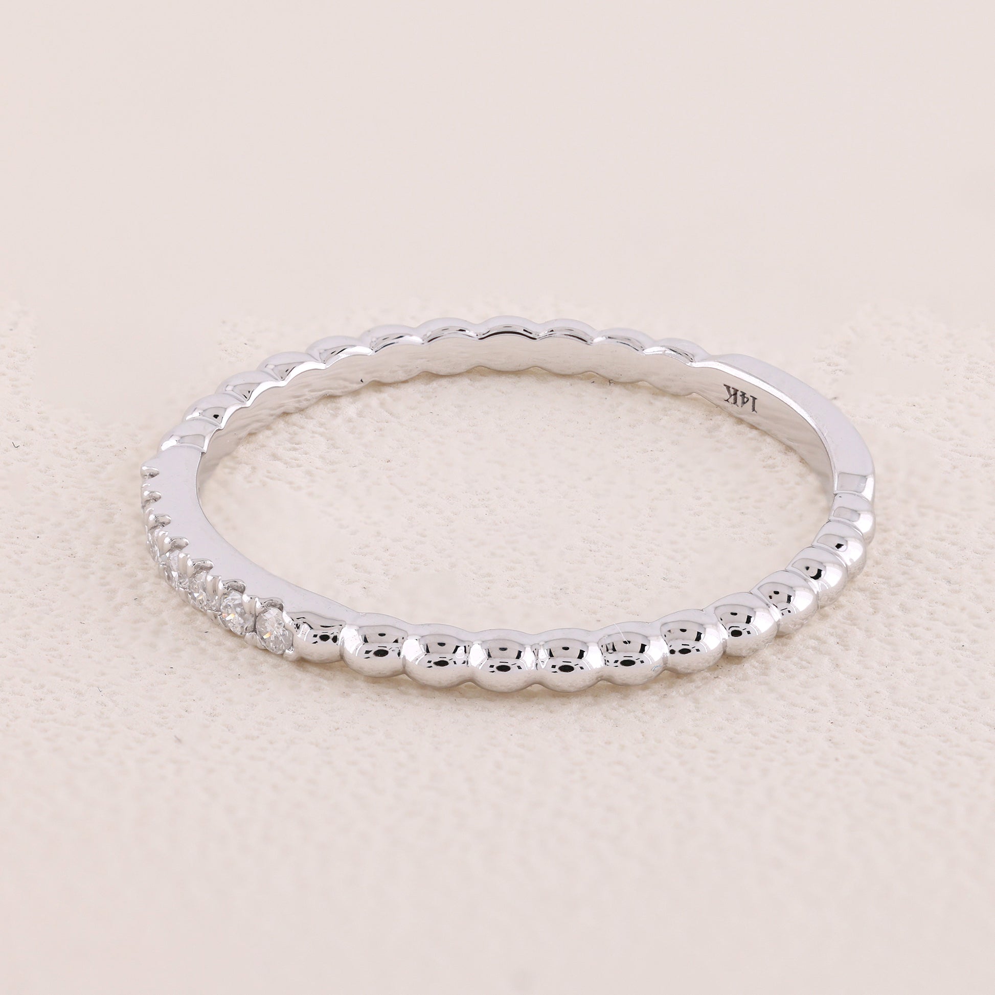 Silver ring with beaded design on a light beige background