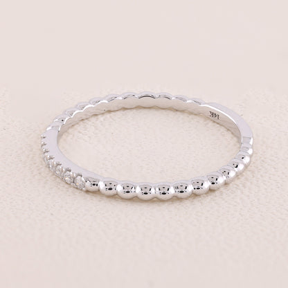 Silver ring with beaded design on a light beige background