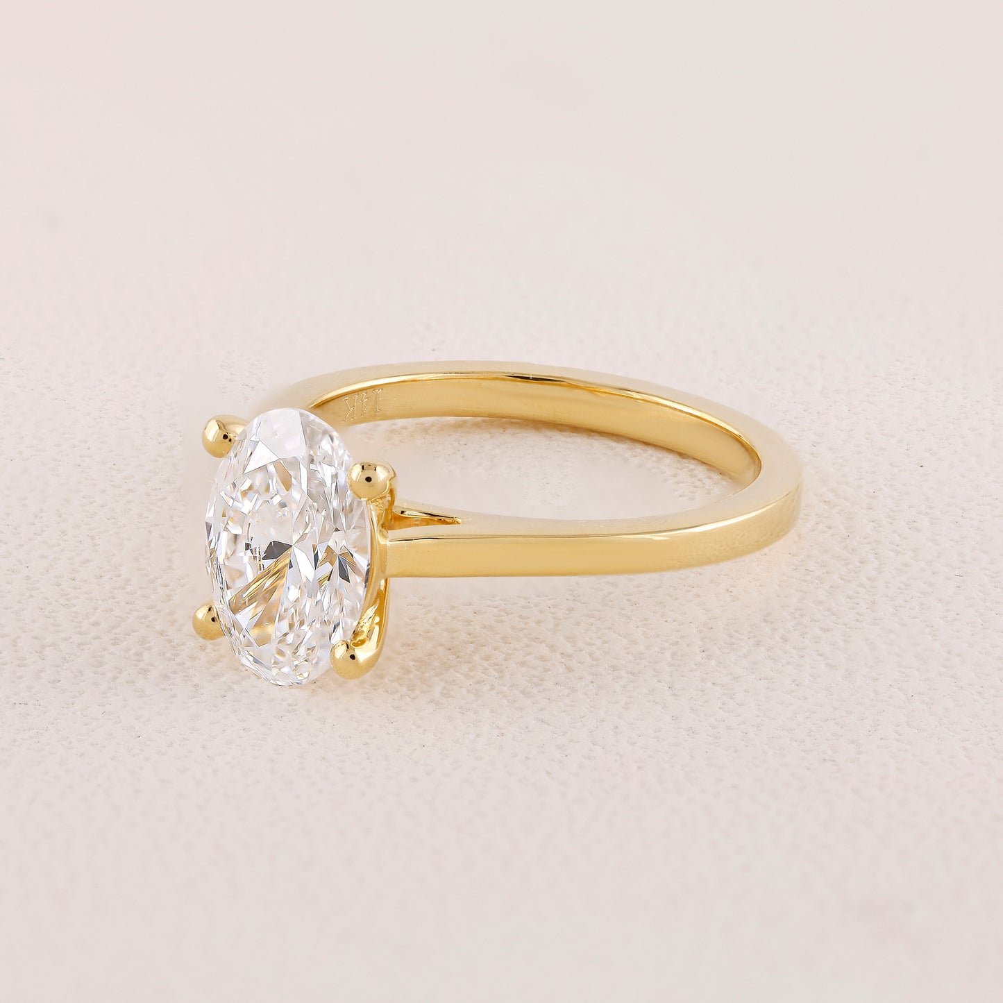 Gold ring with a large diamond on a light beige background