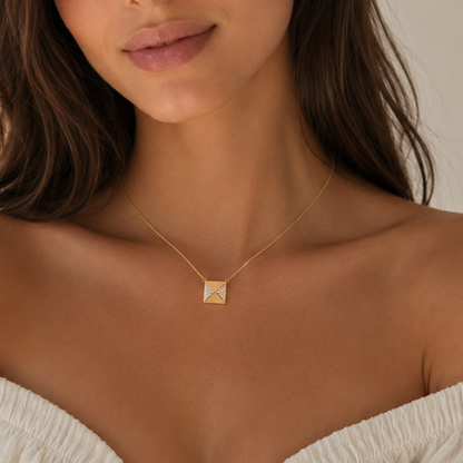 Close-up of a woman wearing a gold necklace with a butterfly pendant.