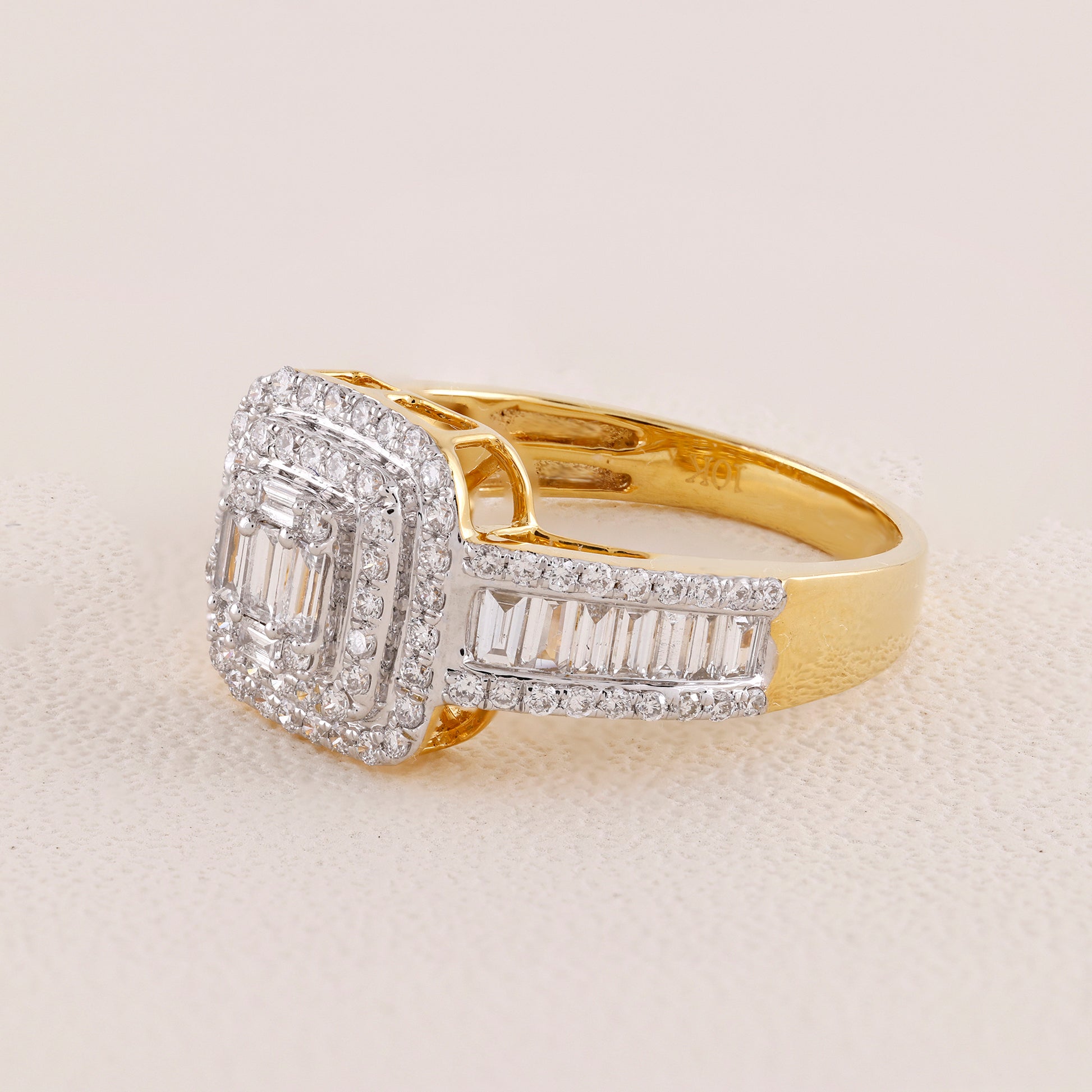 Gold ring with diamond accents on a beige background