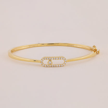 Gold bracelet with a smaall diamond on a beige background