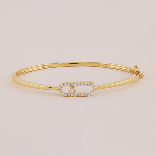 Gold bracelet with a smaall diamond on a beige background