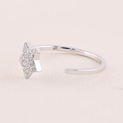 Silver ring with a small diamond on a light pink background