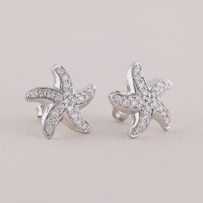 Starfish-shaped earrings with diamond accents on a light gray background