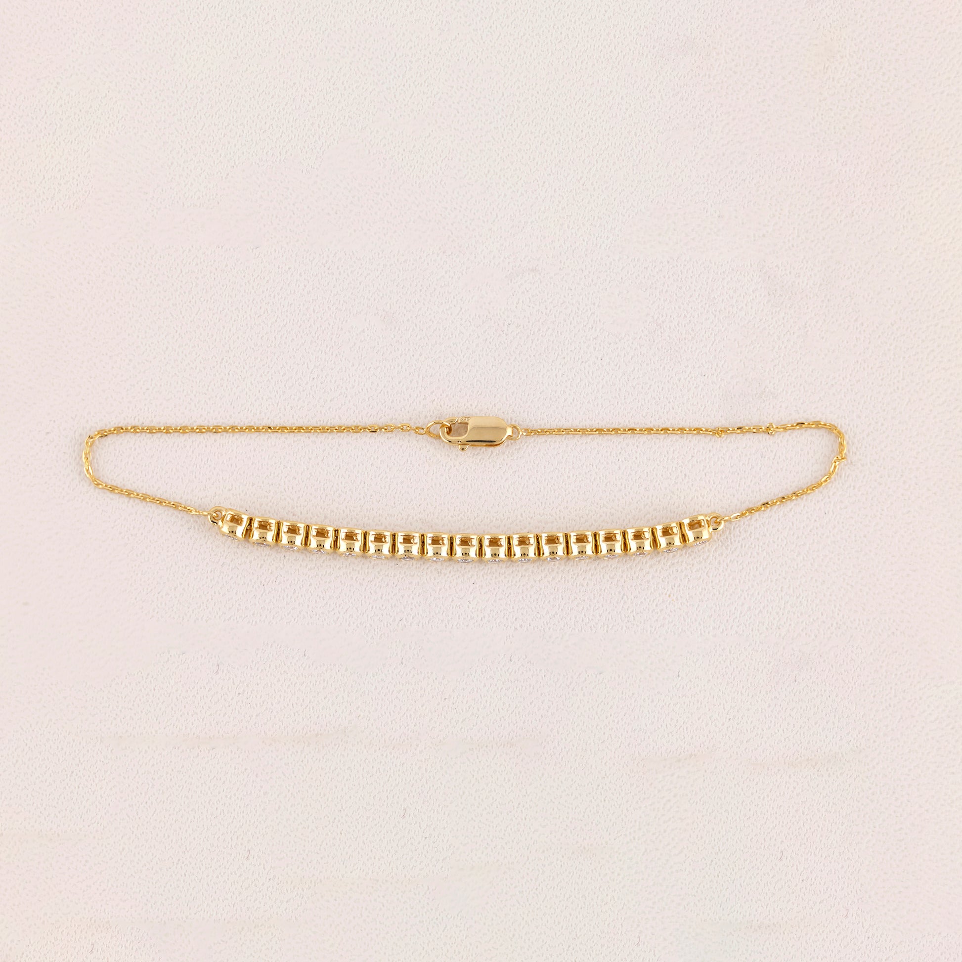 Gold bracelet on a light beige background