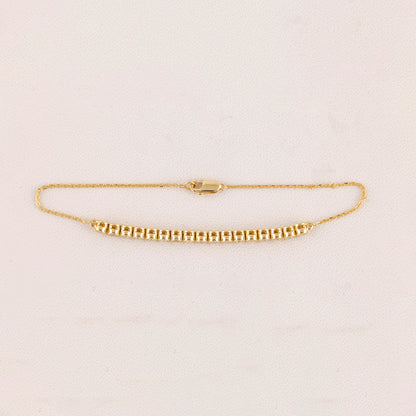 Gold bracelet on a light beige background