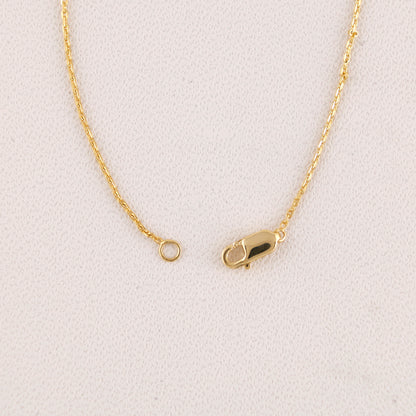 Gold necklace with clasp on a light gray background