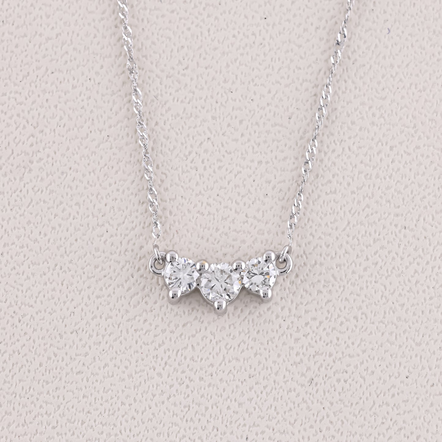 Silver necklace with a butterfly-shaped pendant on a light gray background