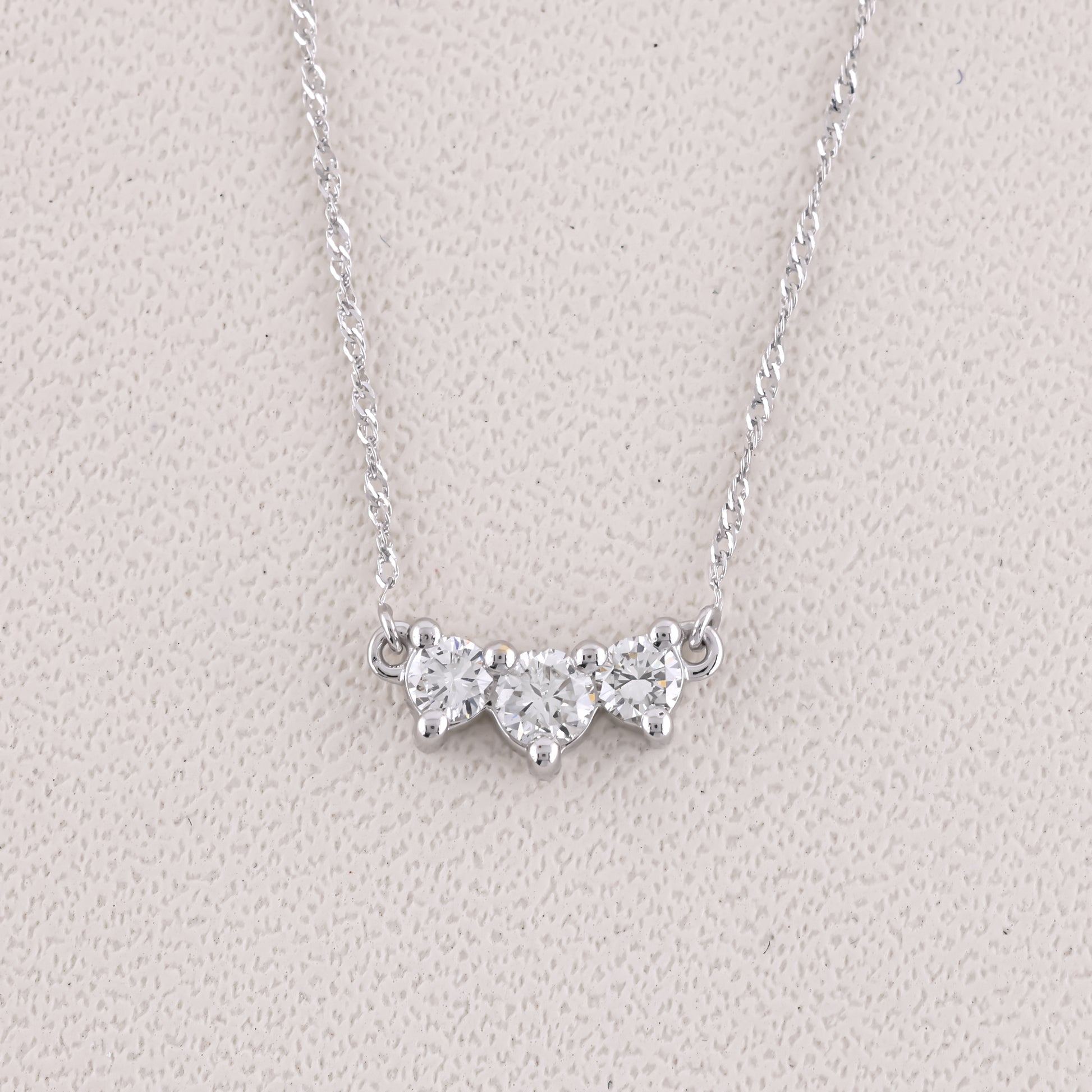 Silver necklace with a butterfly-shaped pendant on a light gray background