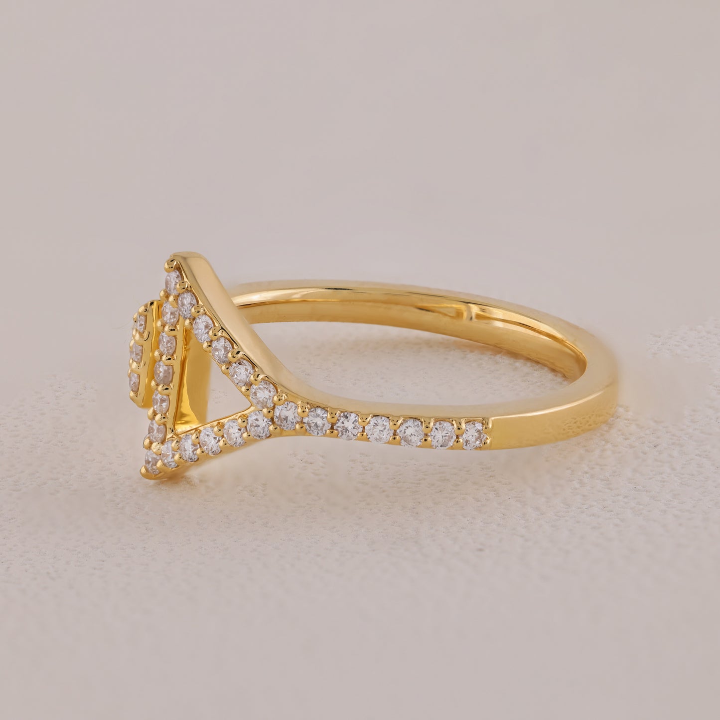 Gold ring with diamond accents on a beige background