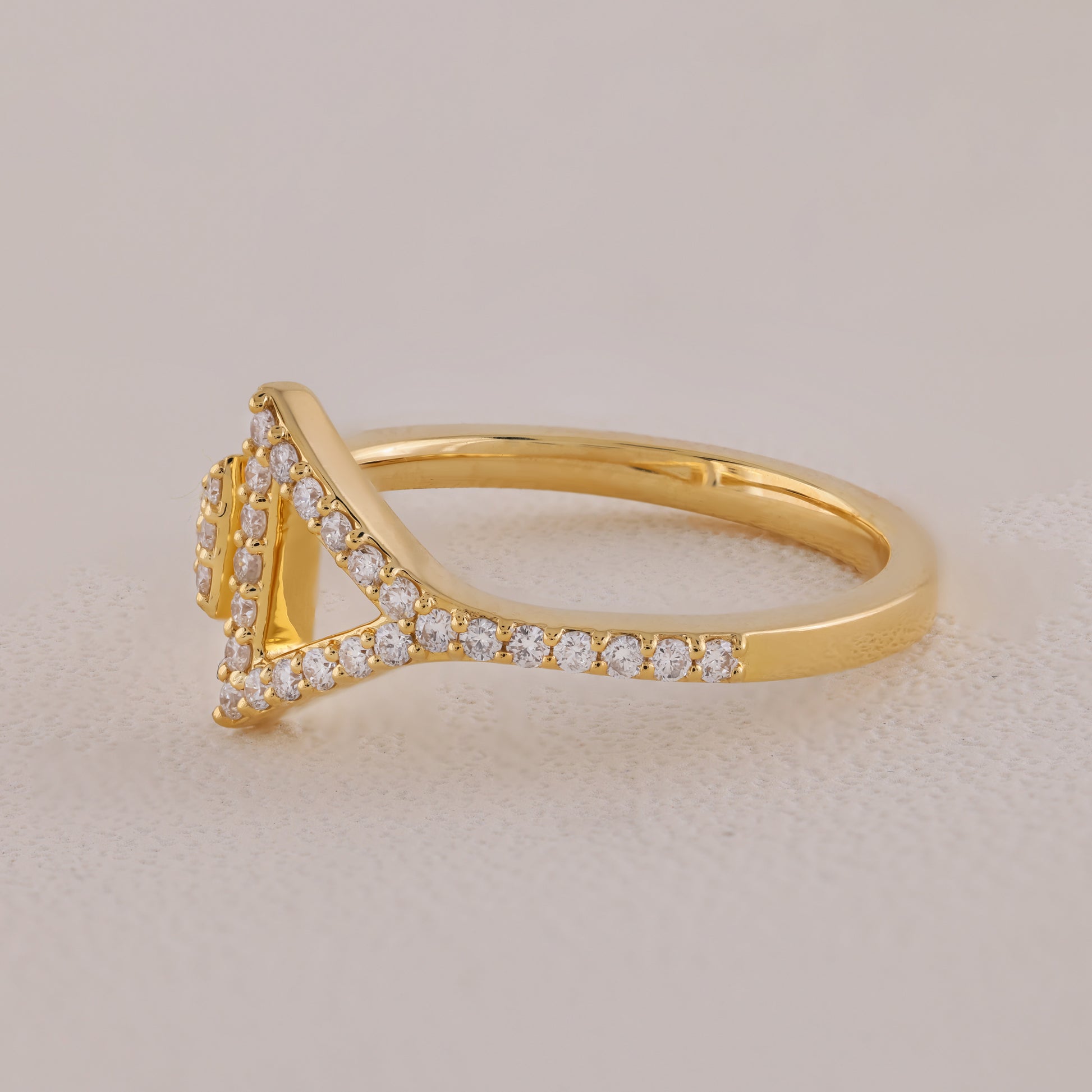 Gold ring with diamond accents on a beige background