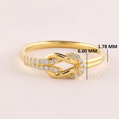 Gold ring with diamond accents on a light beige background, showing measurements.