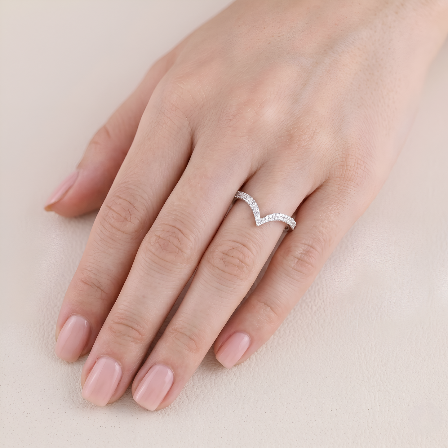 Heart-shaped ring on a hand with a soft background
