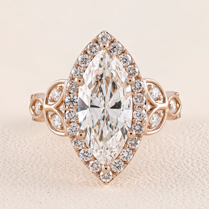 Rose gold ring with a large marquise-shaped diamond and smaller diamonds on a beige background