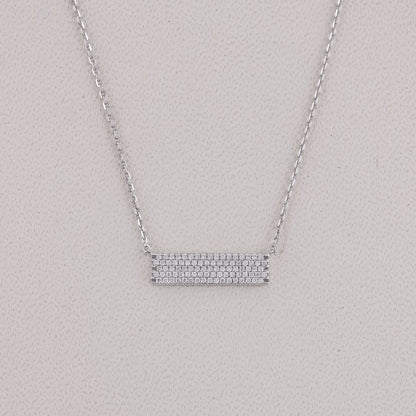 Silver necklace with a bar pendant on a light gray background