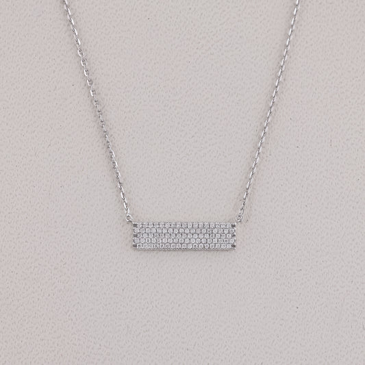 Silver necklace with a bar pendant on a light gray background