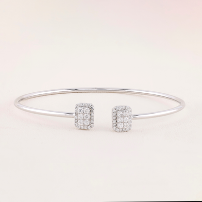 Silver bracelet and earrings on a light pink background