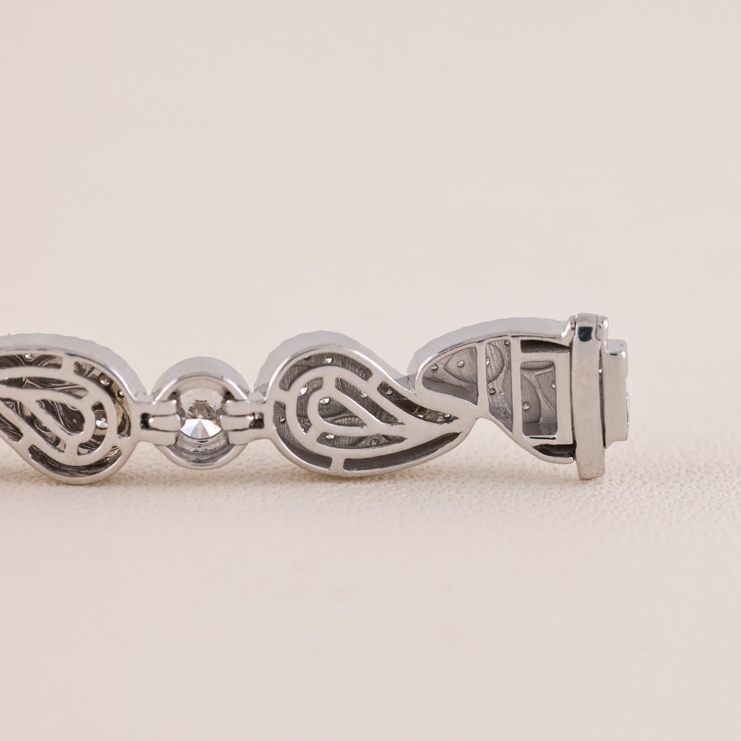 Silver bracelet with intricate design on a light beige background