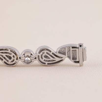 Silver bracelet with intricate design on a light beige background