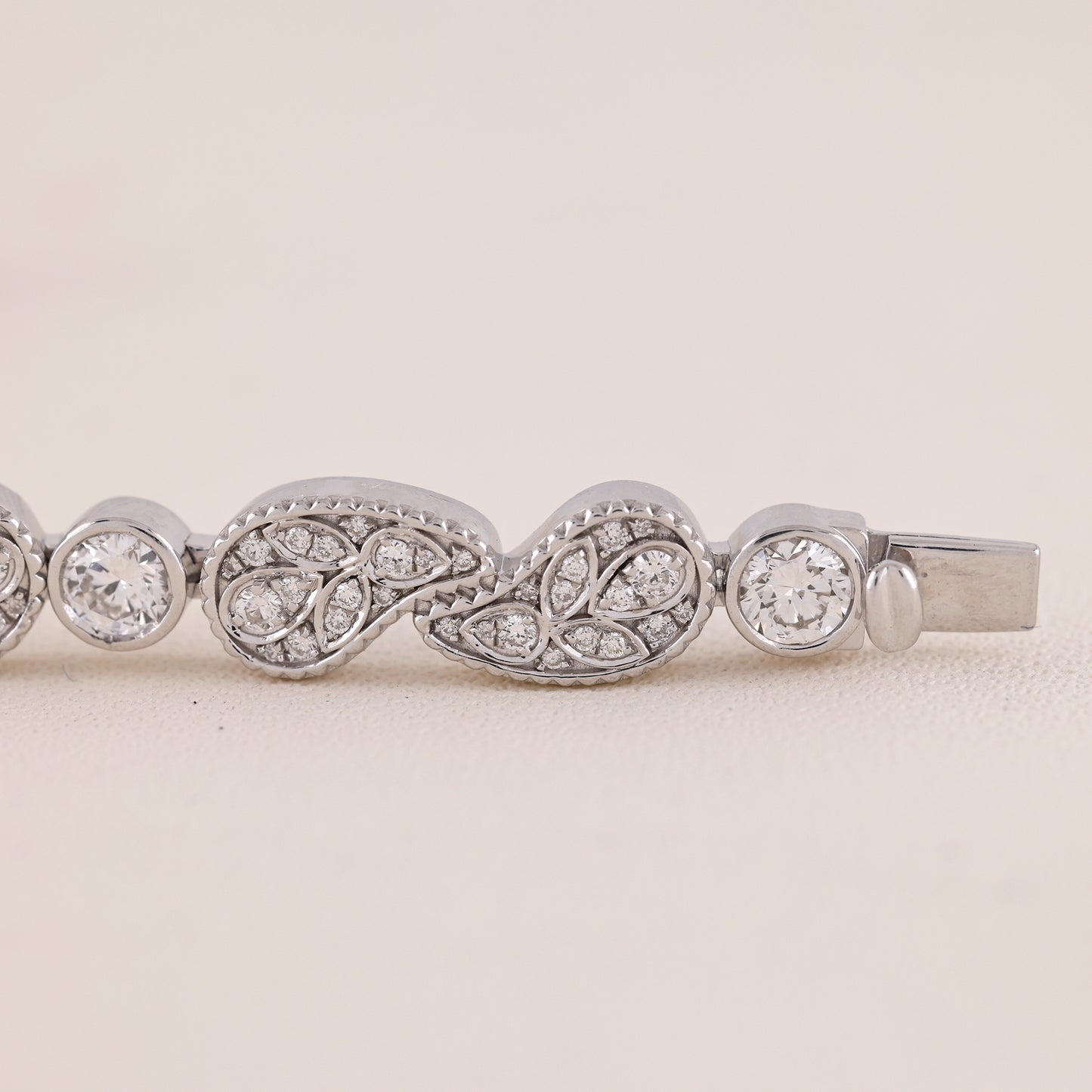 Silver bracelet with diamond accents on a light beige background