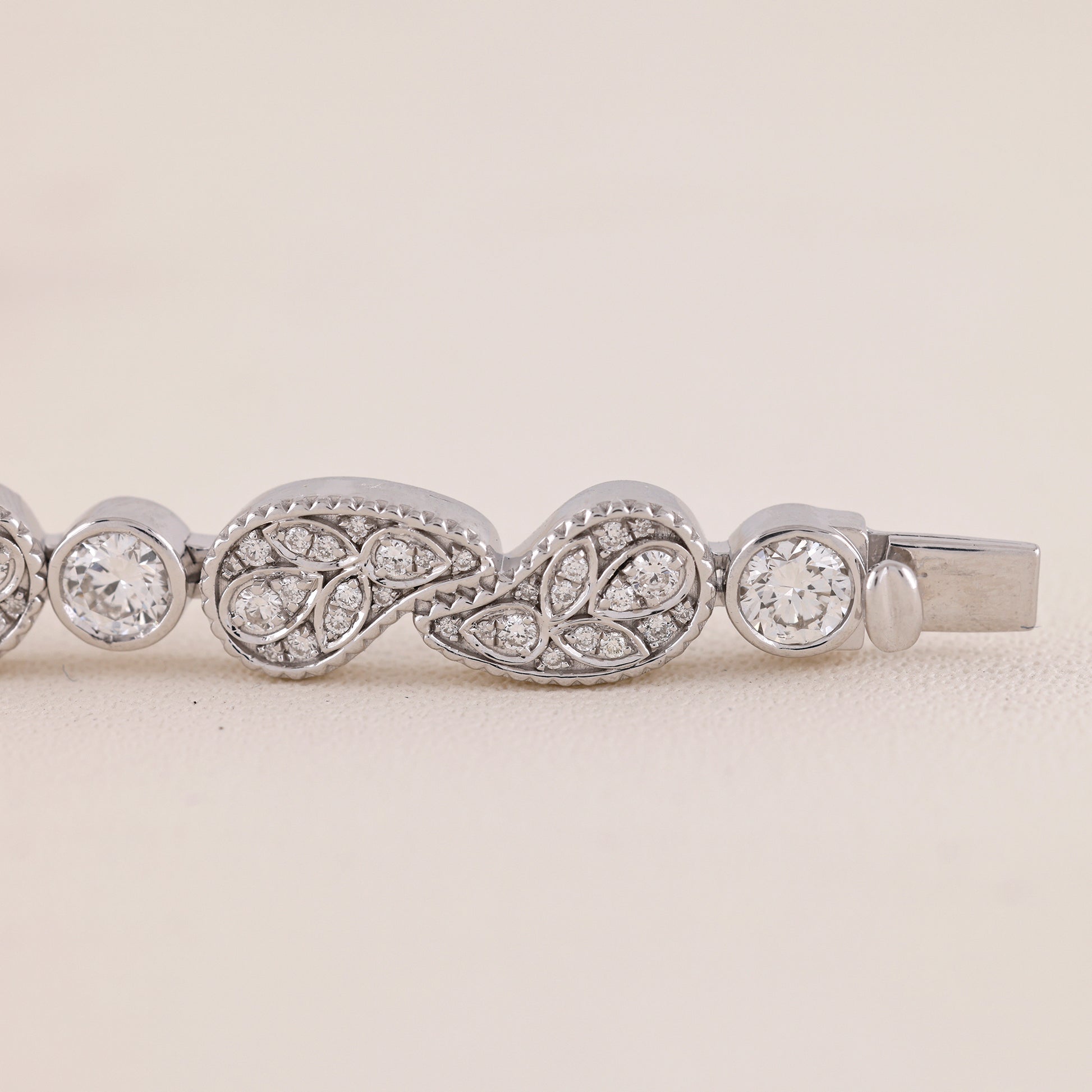 Silver bracelet with diamond accents on a light beige background