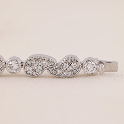 Silver bracelet with diamond accents on a light beige background