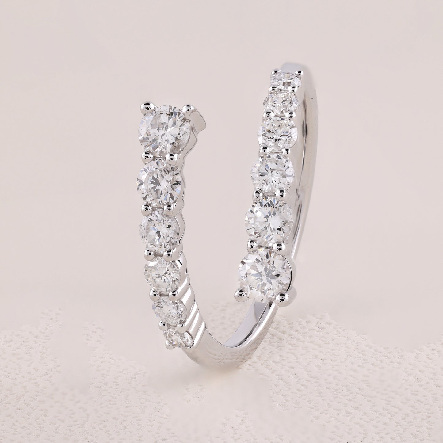 Silver hoop earring with clear gemstones on a light gray background