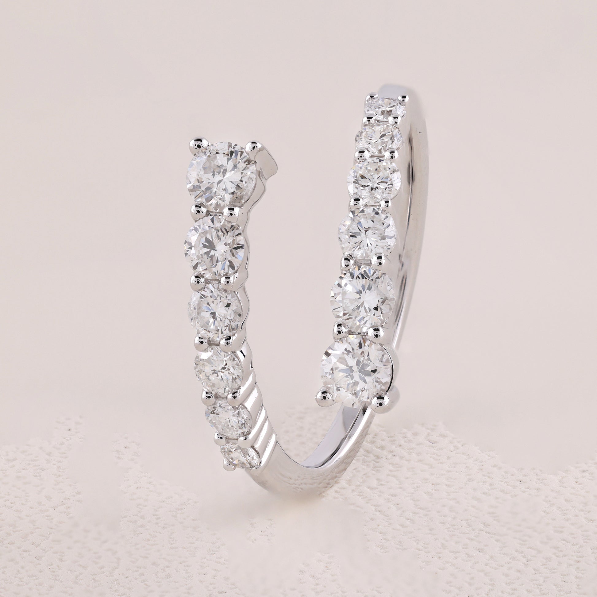 Silver hoop earring with clear gemstones on a light gray background