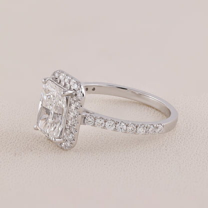 Diamond ring with a rectangular center stone and smaller stones on a light background