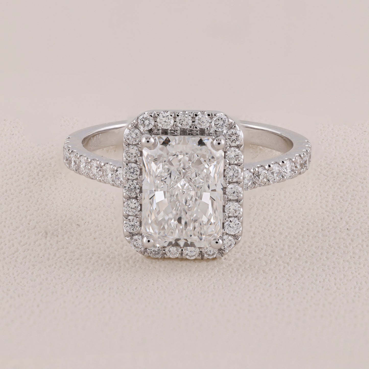 Diamond ring with a rectangular center stone on a light gray background