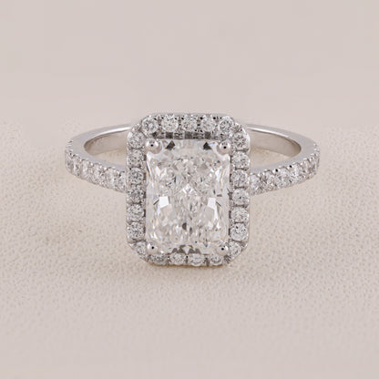Diamond ring with a rectangular center stone on a light gray background