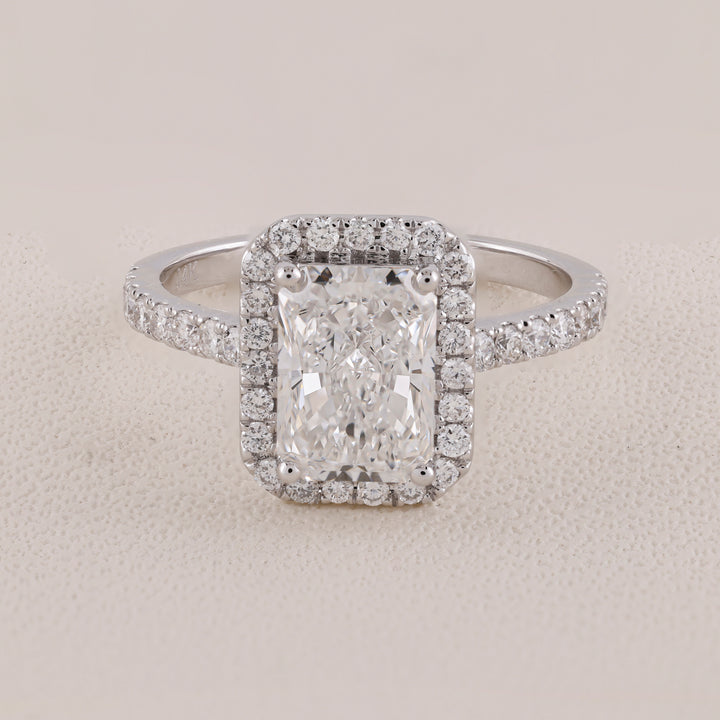 Diamond ring with a rectangular center stone on a light gray background