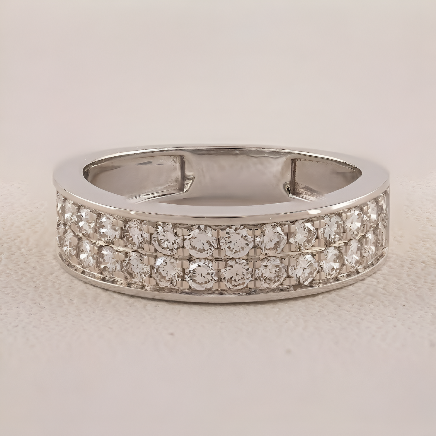 Silver ring with diamond accents on a light gray background