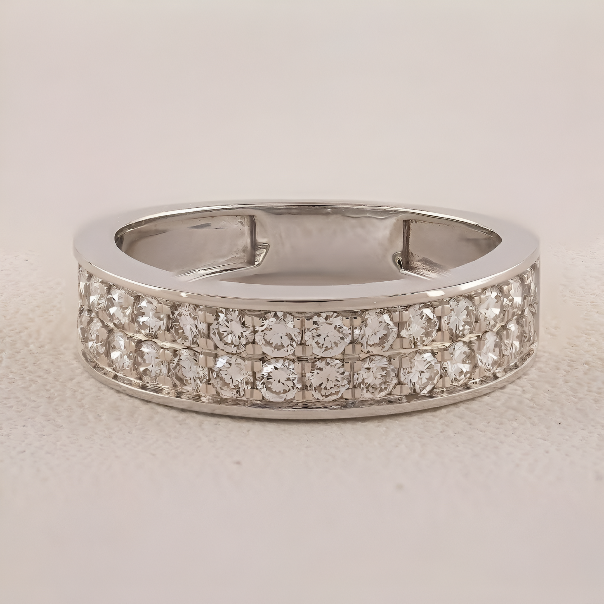 Silver ring with diamond accents on a light gray background
