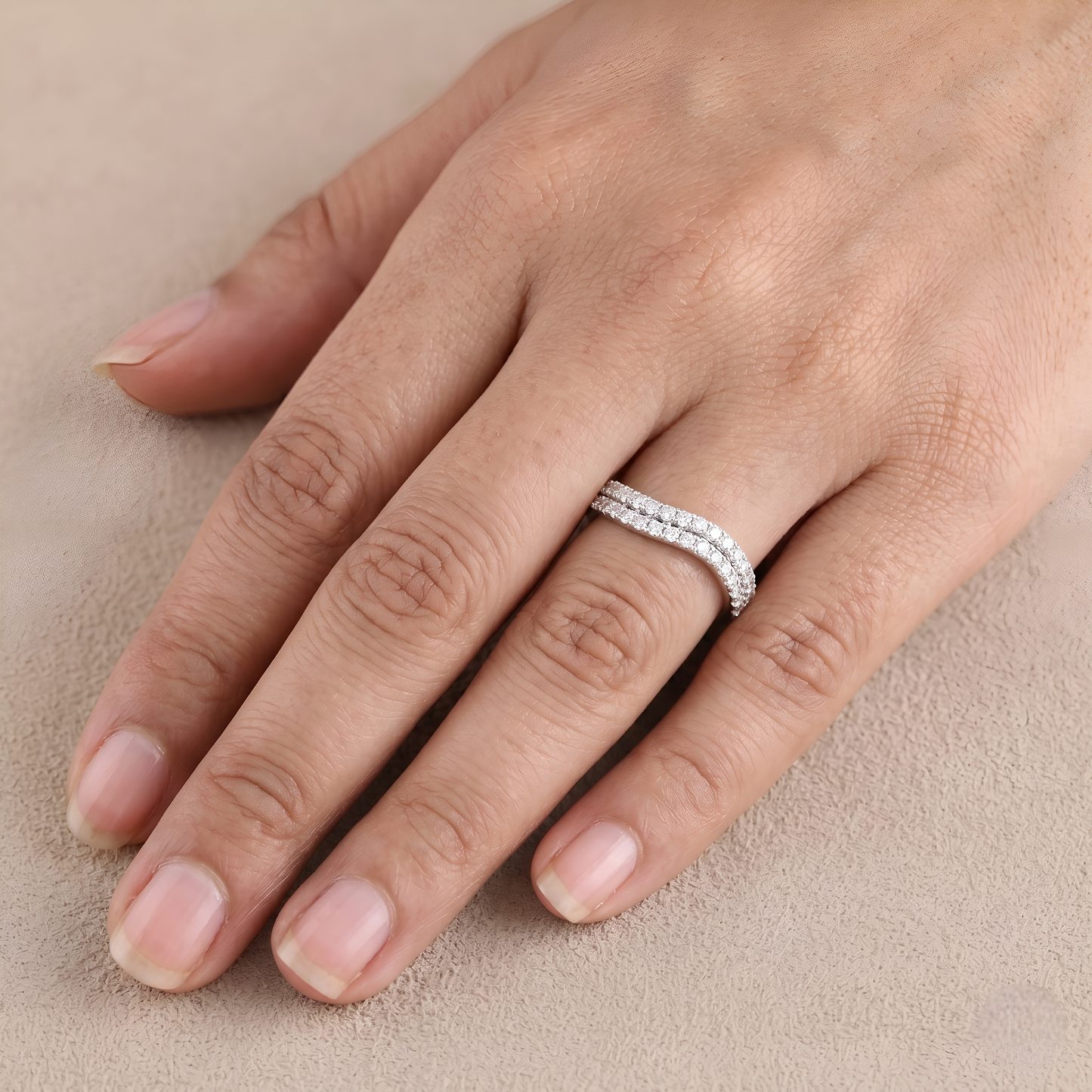 Rose gold ring with a large diamond on a light beige background