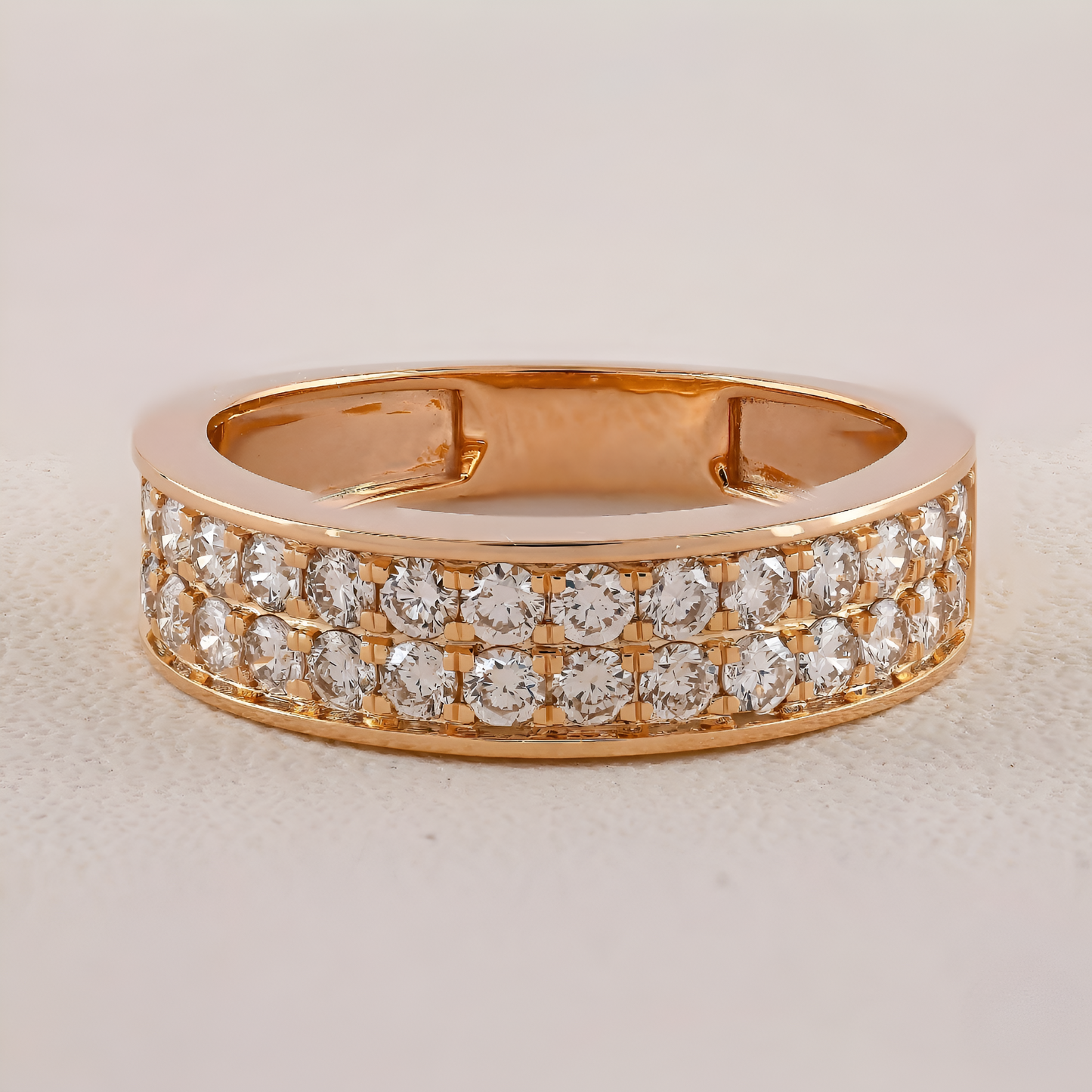 Gold ring with diamond accents on a light beige background