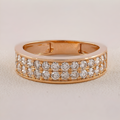 Gold ring with diamond accents on a light beige background