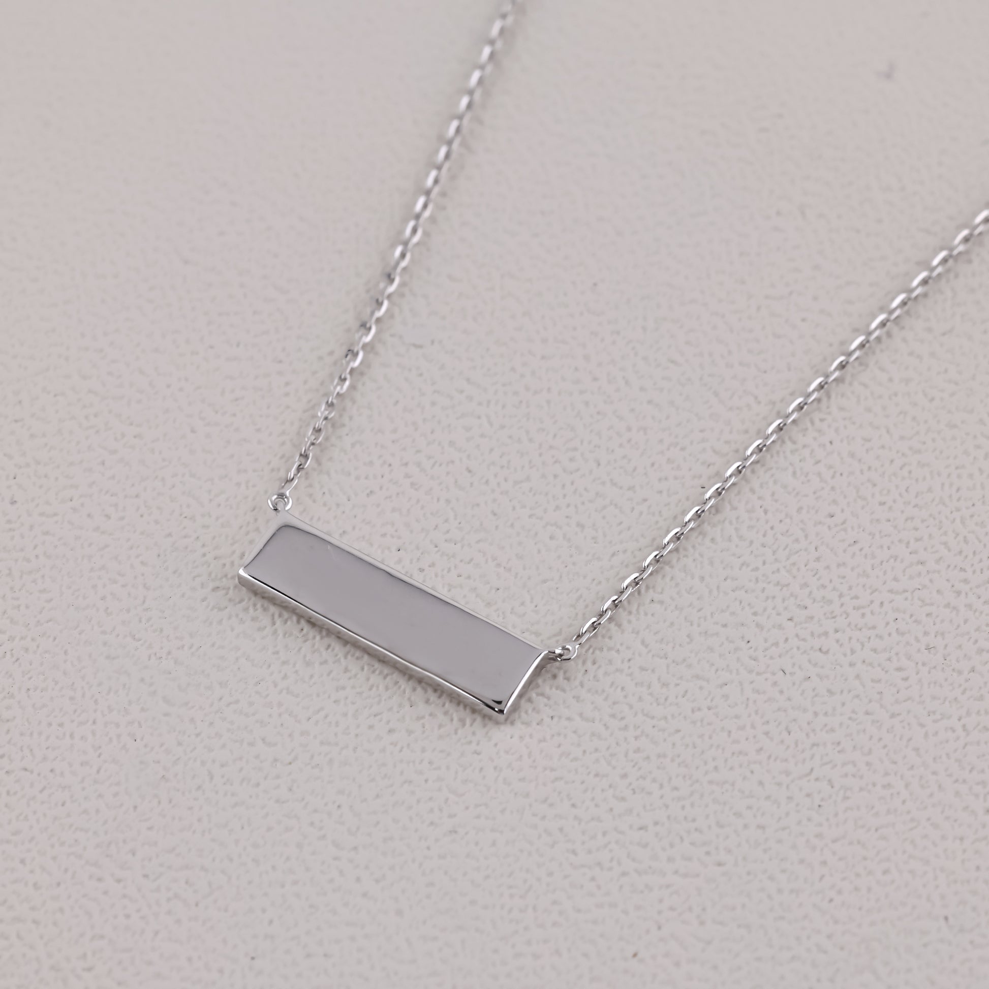 Silver bar necklace on a light gray background
