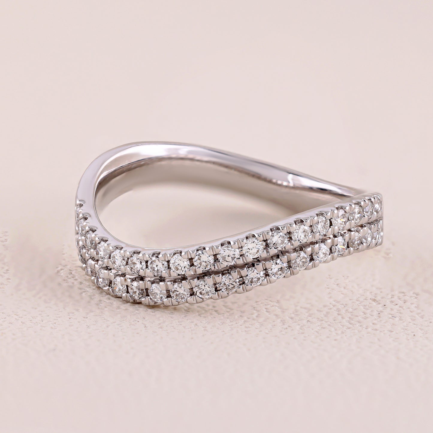 Silver ring with diamond accents on a beige background