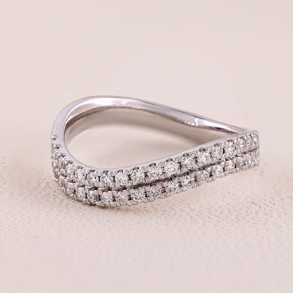 Silver ring with diamond accents on a beige background