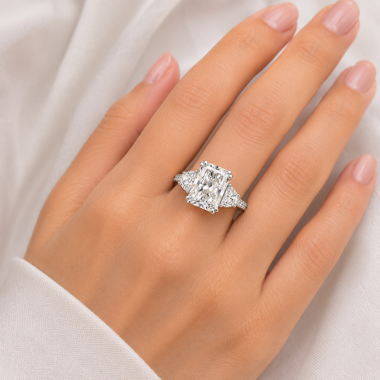 Diamond ring on a hand against a neutral background